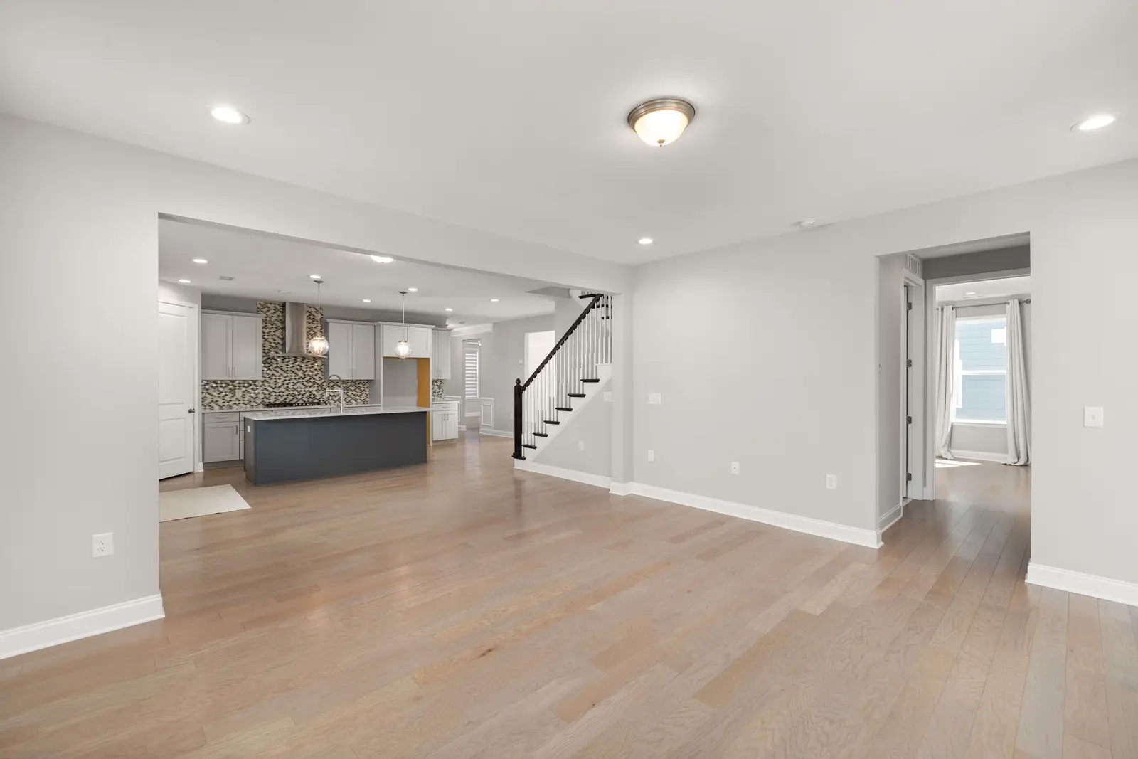 A wide plank wood look floor running through an open plan living and kitchen space