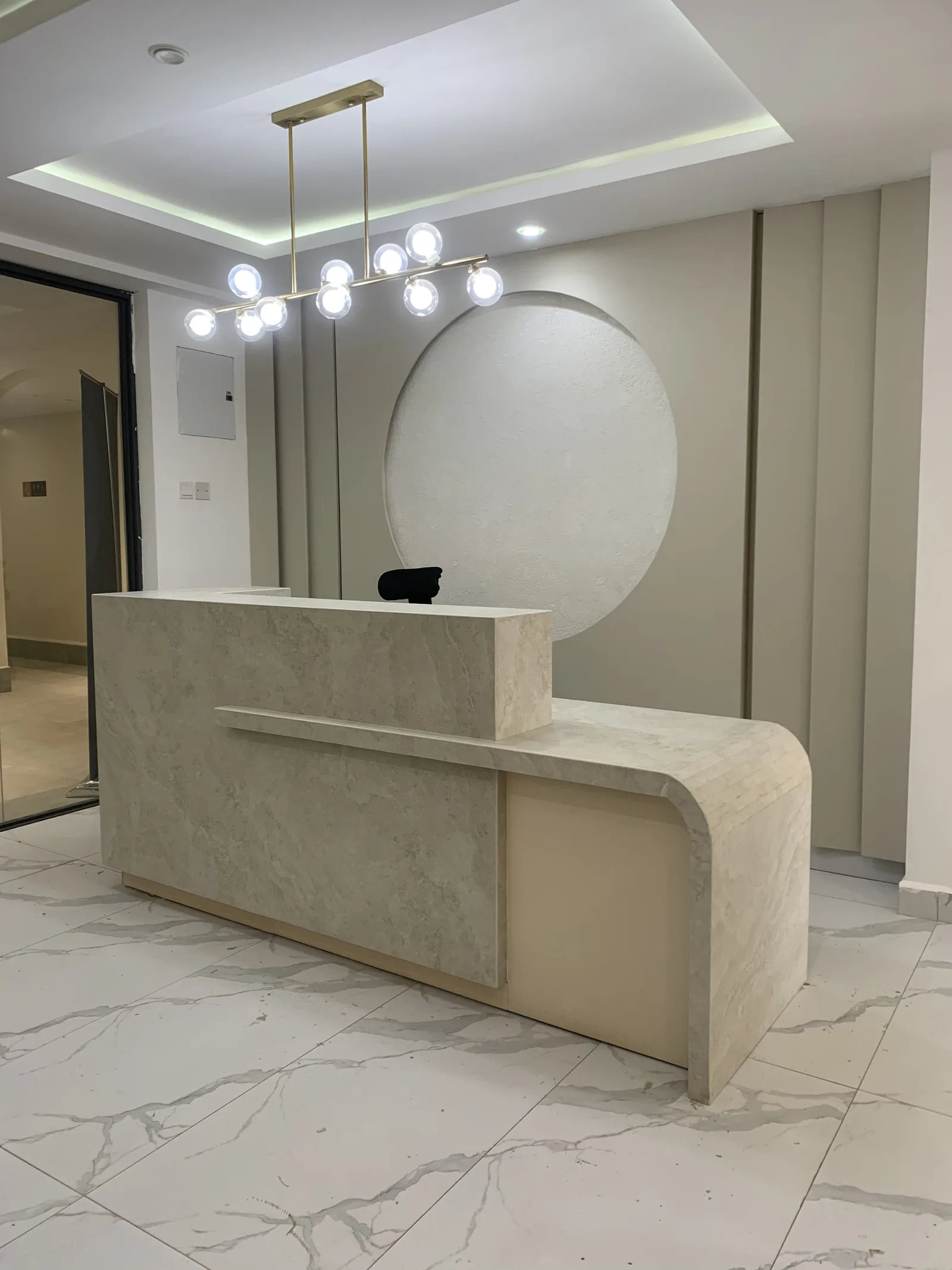 A curved stone reception desk in an office lobby